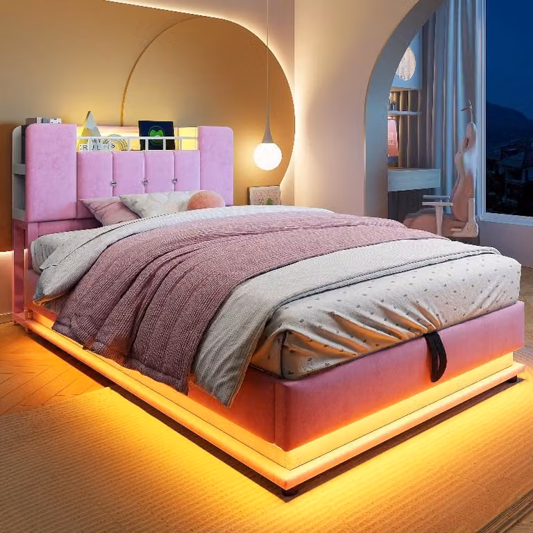 Letto imbottito Kinder 90x200 cm, color rosa, con illuminazione a LED, porta USB, spazio contenitore ad apertura idraulica e rivestimento in velluto, struttura in metallo con mensola integrata nella testiera