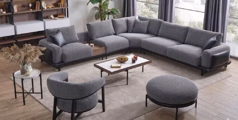 Zona living divano angolare a forma di L, poltrona, poggiapiedi, 2 tavolini, colore grigio