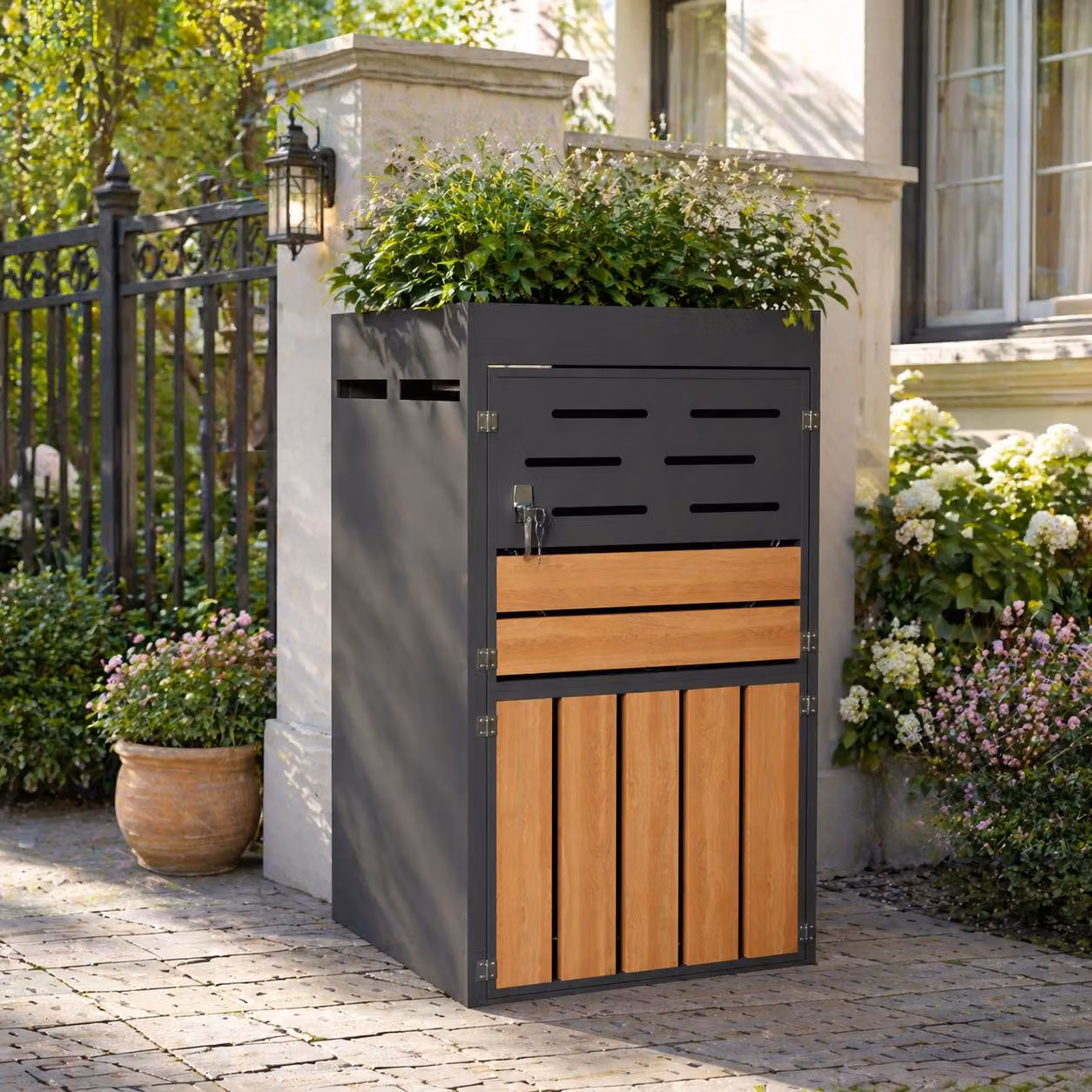 Armadietto per bidoni della spazzatura con fioriera integrata, sistema di ventilazione a lamelle, porte con serratura e struttura in acciaio zincato, dimensioni 66 x 80 x 128 cm