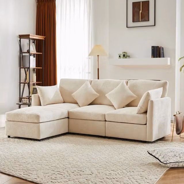 Divano angolare modulare REDOM in tessuto beige con pouf e cuscini, L/P/H: 216 x 161 x 81 cm
