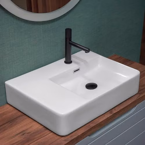 Lavabo da appoggio 60x43 rettangolare in ceramica lucida, vasca decentrata a destra e ripiano d’appoggio, forato per troppo pieno e rubinetteria