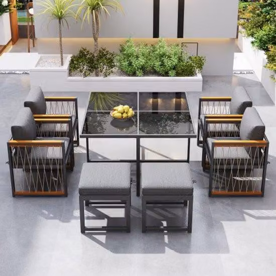 Set da 6 posti per esterni, composto da 7 elementi, con tavolo in vetro temperato e braccioli in legno di acacia, ideale per pranzare all'aperto o in terrazza.