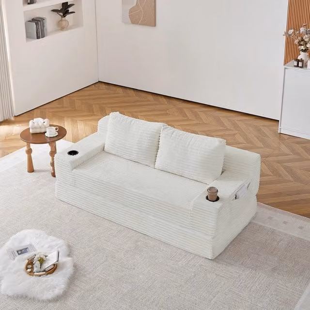 Divano letto 2 posti Minimal in tessuto beige con 2 cuscini, portabibite e tasche portaoggetti