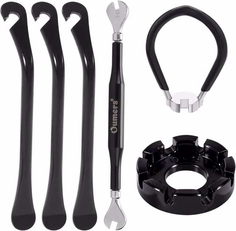 Set di strumenti per la riparazione di biciclette, composto da 7 pezzi: 3 chiavi per raggi, 3 leve per pneumatici, e un utensile per la sostituzione delle valvole