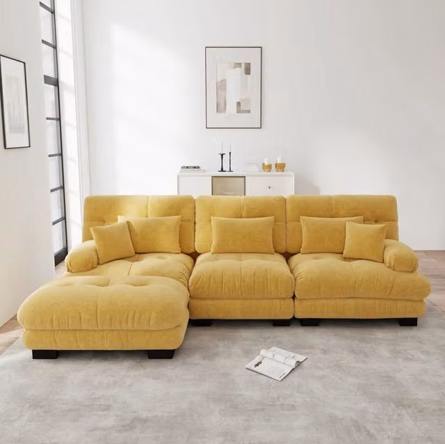 Divano modulare angolare con pouf mobili in ciniglia gialla; seduta profonda stile cloud