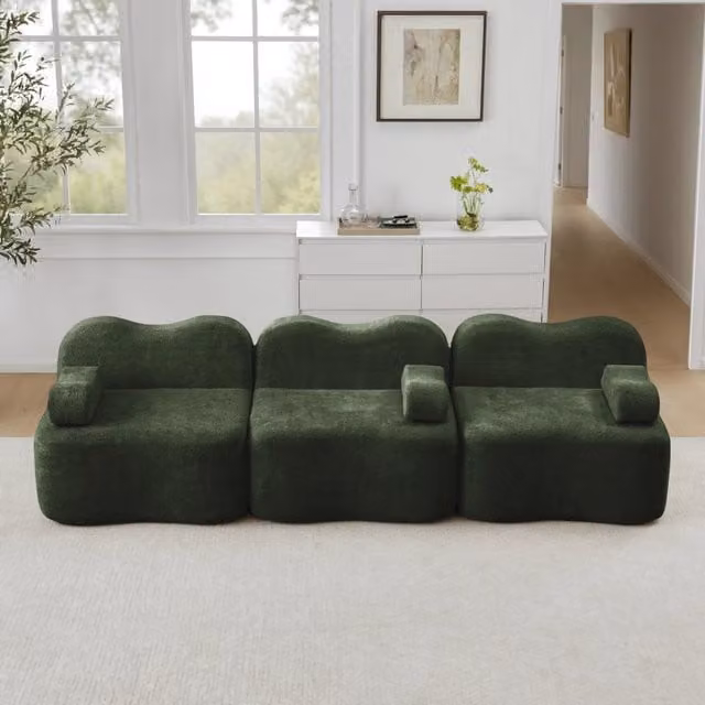 Divano angolare modulare REDOM in velluto verde con pouf e cuscini coordinati per il tuo soggiorno