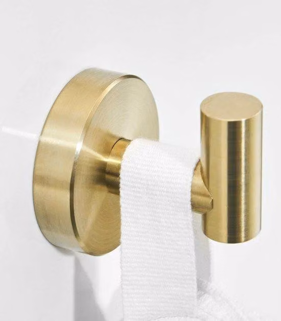 Accessori da bagno in acciaio inossidabile con design a tre elementi, fissaggio a parete, finitura dorata e superficie spazzolata.