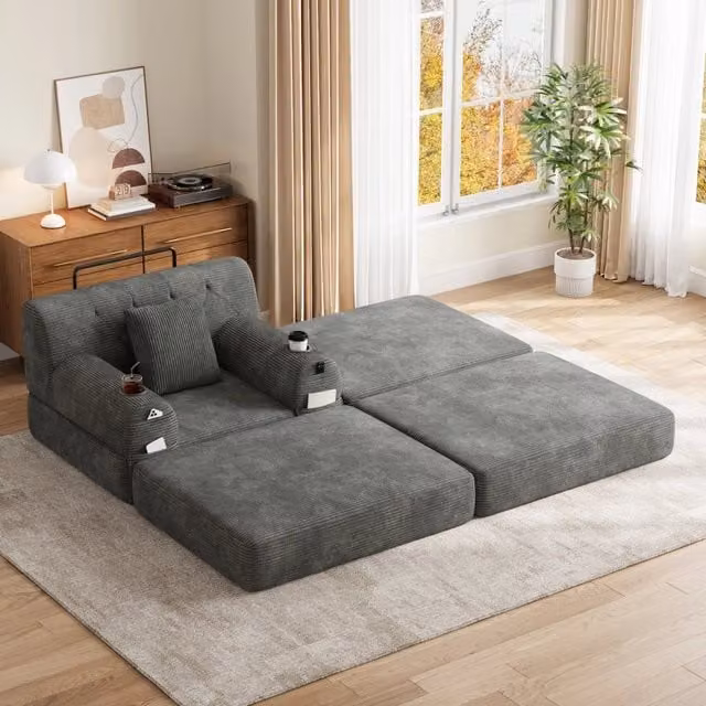 Letto convertibile 1 con pouf; schienale alto; portabicchieri 2 e tasche laterali 4; velluto a coste; grigio