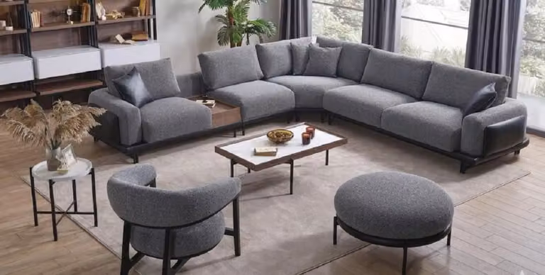 Zona living divano angolare a forma di L, poltrona, poggiapiedi, 2 tavolini, colore grigio