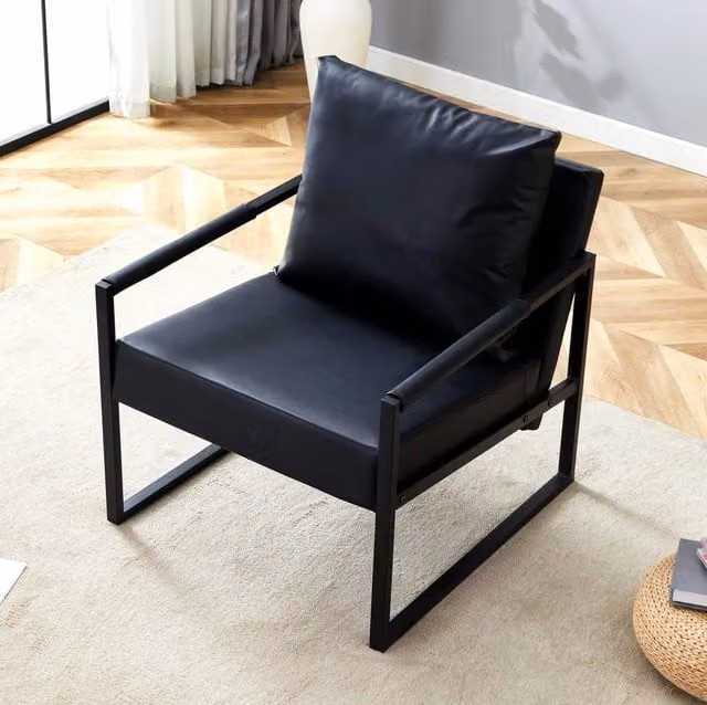 Poltrona da lettura nera in pelle sintetica con telaio metallico e imbottitura confortevole