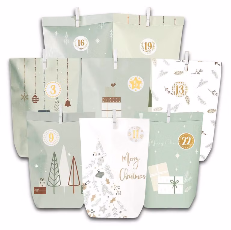 Calendario dell'Avvento da realizzare, composto da 28 sacchetti di carta con motivi natalizi, numeri adesivi, graffette di legno e nastro verde