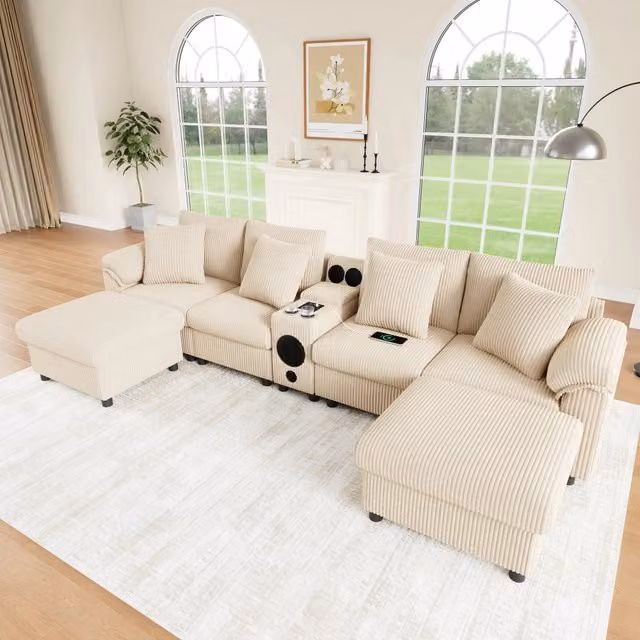 Divano modulare a L OKWISH in tessuto beige con altoparlante Bluetooth, console di ricarica USB e Type C, portabicchieri e cuscini inclusi L/P/H: 315.5 x 144 x 84.5 cm