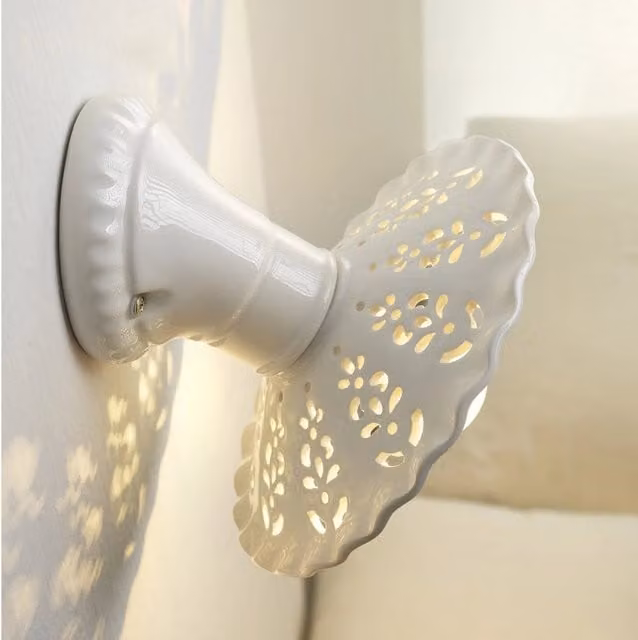 Applique da parete MERLETTO in ceramica bianca di Ceramiche Borso con design traforato e base obliqua Ø21 cm