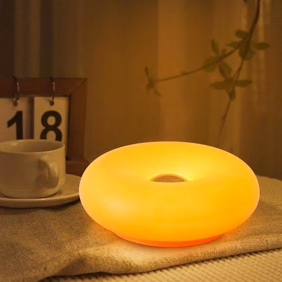 Lampada da tavolo ricaricabile e regolabile, a forma di ciambella. Ideale per la camera da letto, con funzione di ricarica USB, color arancione.