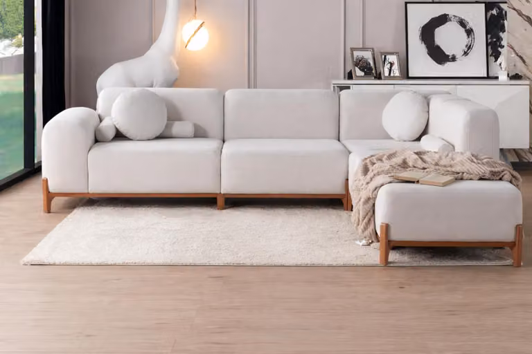 Moderno divano ad angolo bianco con gambe in legno ed eleganti cuscini: mobili di alta qualità