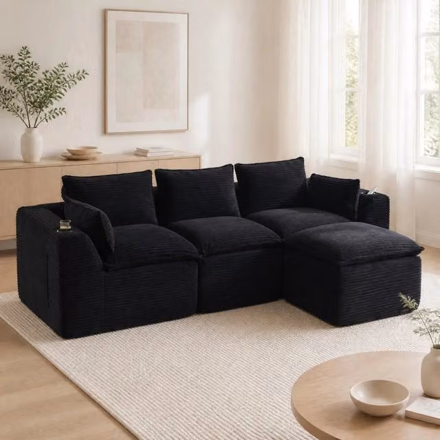 Divano modulare a L MIVRAY in velluto a coste nero con pouf e cuscini, imbottitura mista e tasche laterali