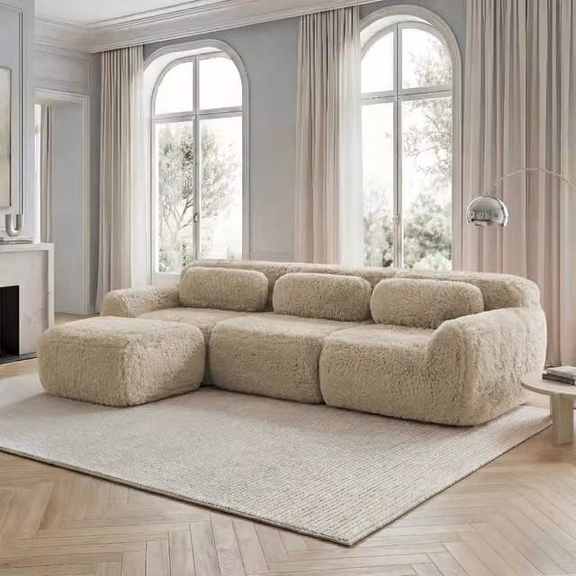 Divano angolare modulare MIVRAY in tessuto peluche beige con pouf coordinato e design moderno reversibile