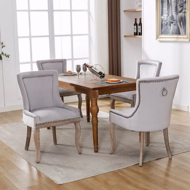 Sedia da pranzo imbottita in velluto grigio con struttura in legno borchie decorative e gambe anteriori curve