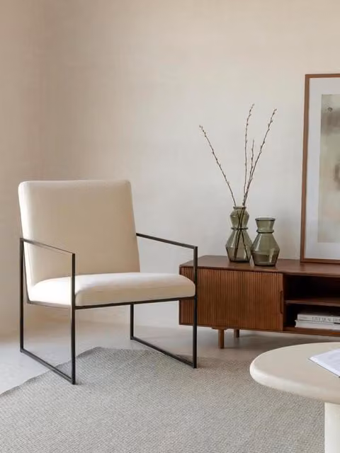 Poltrona imbottita Heide Kenay Home beige con struttura in metallo nero e braccioli