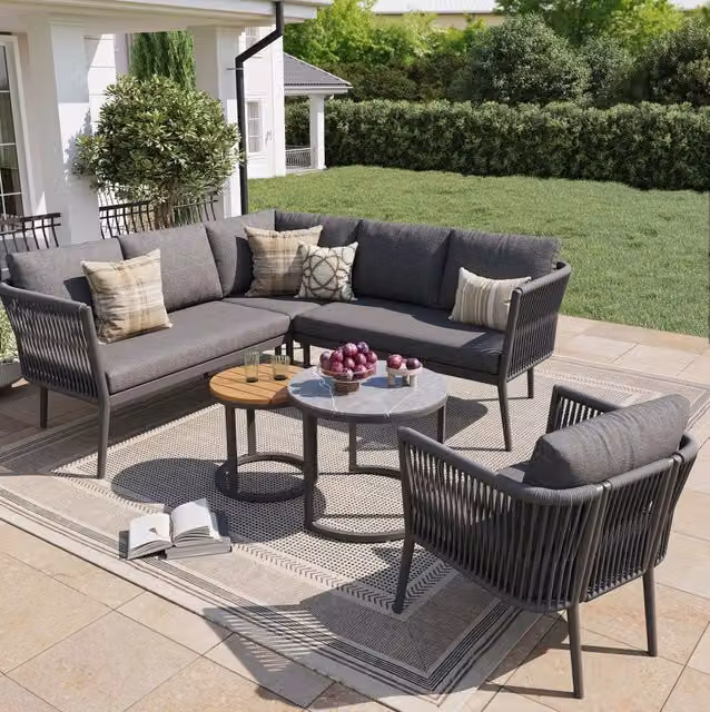 Set salotto da giardino moderno a forma di L con poltrona lounge, elemento angolare, tavolino da caffè e cuscini in tessuto grigio con struttura in metallo e polyrattan