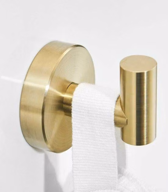 Accessori da bagno in acciaio inossidabile con design a tre elementi, fissaggio a parete, finitura dorata e superficie spazzolata.