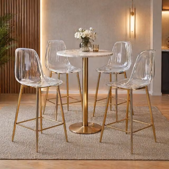 Sgabello da bar moderno Mivray con seduta trasparente in plastica e struttura in metallo dorato lucido con poggiapiedi per cucina e sala da pranzo