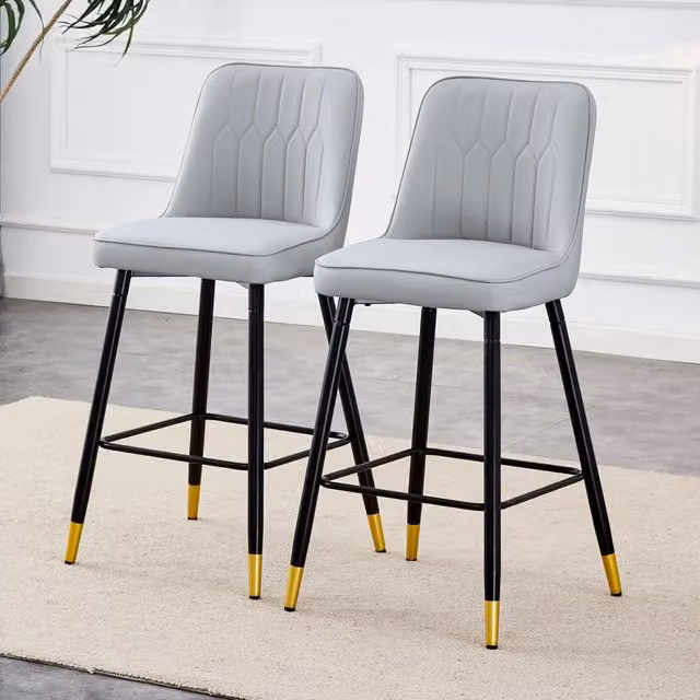 Set di due sgabelli da bar, alti 100 cm, realizzati in similpelle PU grigio chiaro con struttura in metallo nero e comodo poggiapiedi. Disponibili in