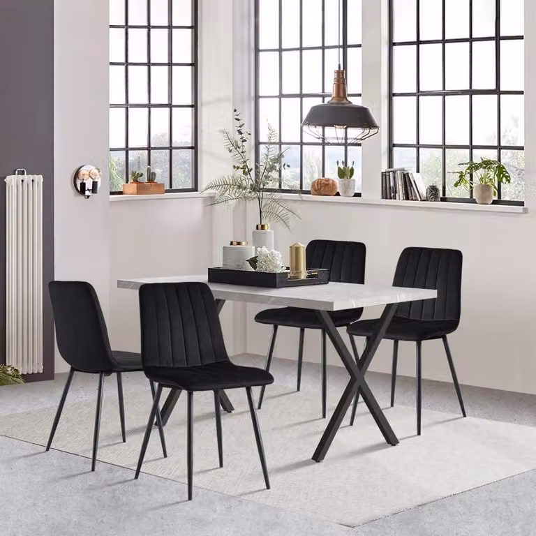 Set da pranzo composto da un tavolo da pranzo di 140x80 cm e 4 sedie. Il tavolo è rettangolare, in legno, con gambe in metallo a forma di "X". Le 4 sedie sono rivestite in velluto, disponibili nei colori nero e grigio