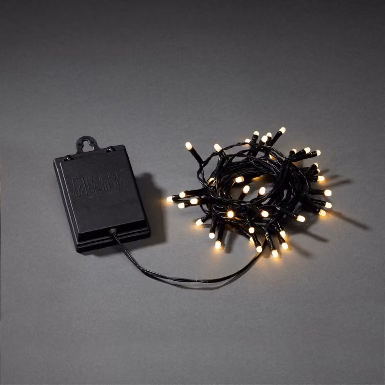 Fata LED Konstsmide, con interruttore on/off e timer 6h, con 8 funzioni e funzione di memoria, smerigliata, 40 diodi bianco caldo, a batteria, per esterni (IP44), cavo nero, batteria: 4 x AA 1,5V (escl.) - 3724-130