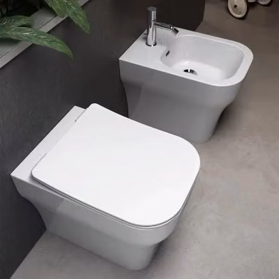 Sanitari filo muro traslati Olympia serie Synthesis in ceramica bianca con copriwater rallentato