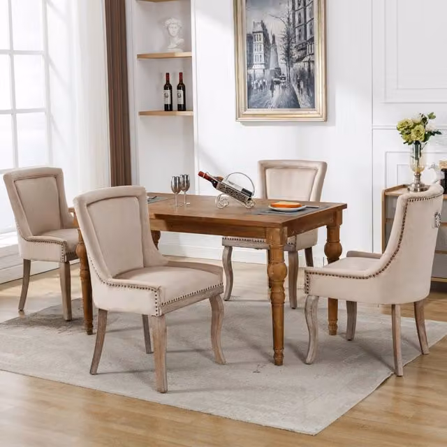 Sedia da pranzo imbottita in velluto beige con borchie; struttura in legno e portata massima di 150 kg
