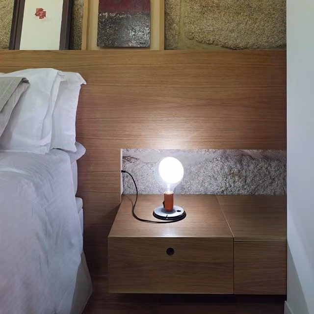 Lampada da tavolo Flos Lampadina con vetro trasparente e finiture argento o nero