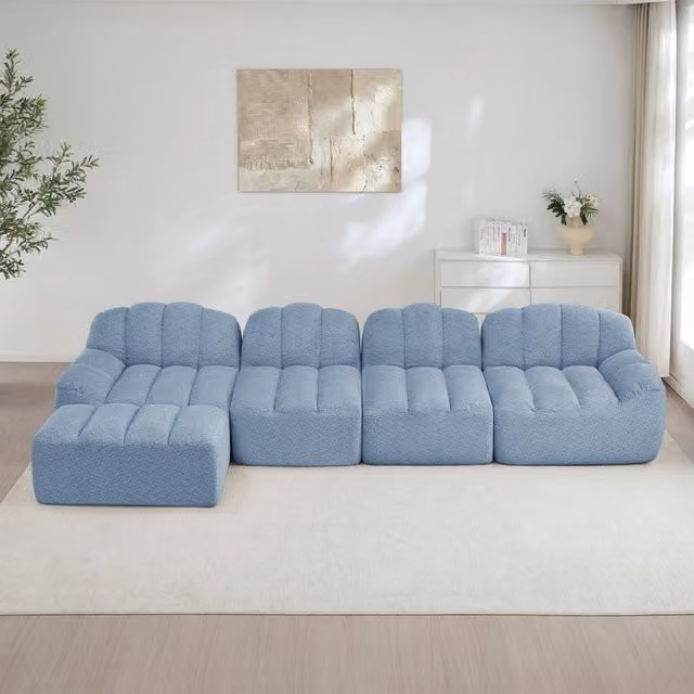 Divano modulare a L OKWISH da 4 posti con pouf coordinato, rivestimento in tessuto blu per soggiorno moderno