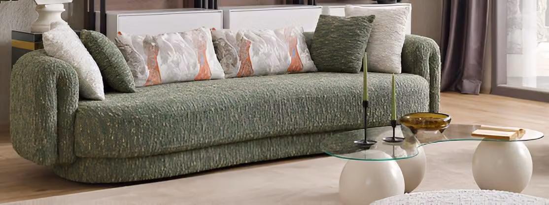 Divano elegante a tre posti, color verde, e set moderno di tavolini da caffè