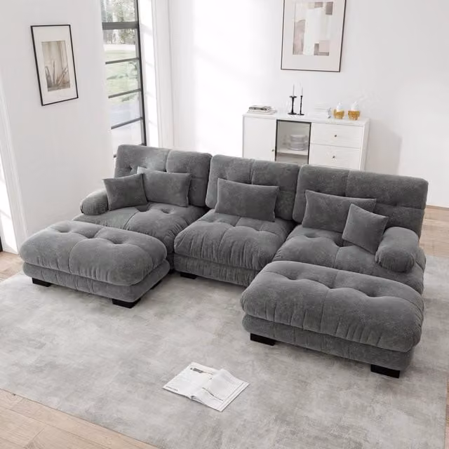 Divano angolare modulare OKWISH in velluto grigio con pouf e cuscini coordinati, design moderno a forma di L con seduta sinistra
